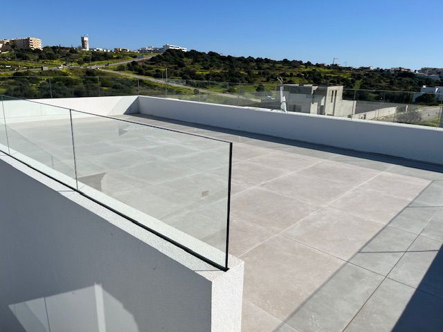 Tiled rooftop terrace with glass balustrades at Porto de Mós