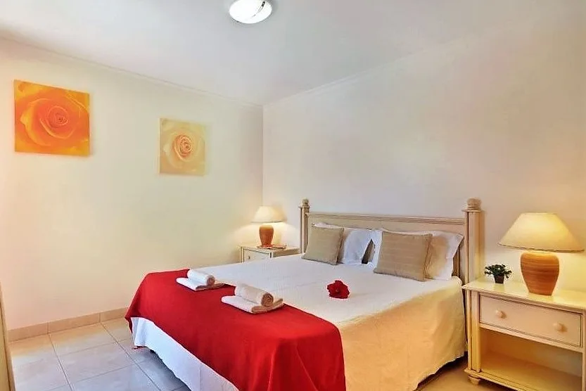 Renovated bedroom with red bedspread at Jardim da Meia Praia, Lagos