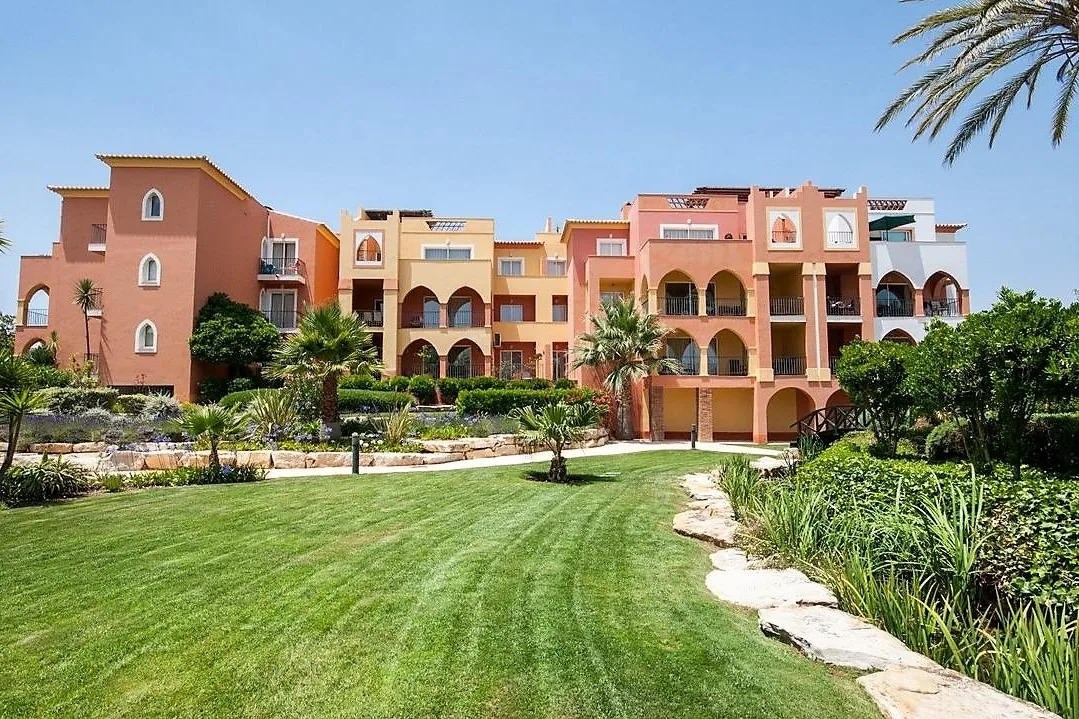 Colourful Jardim da Meia Praia resort buildings beside landscaped lawns, Lagos