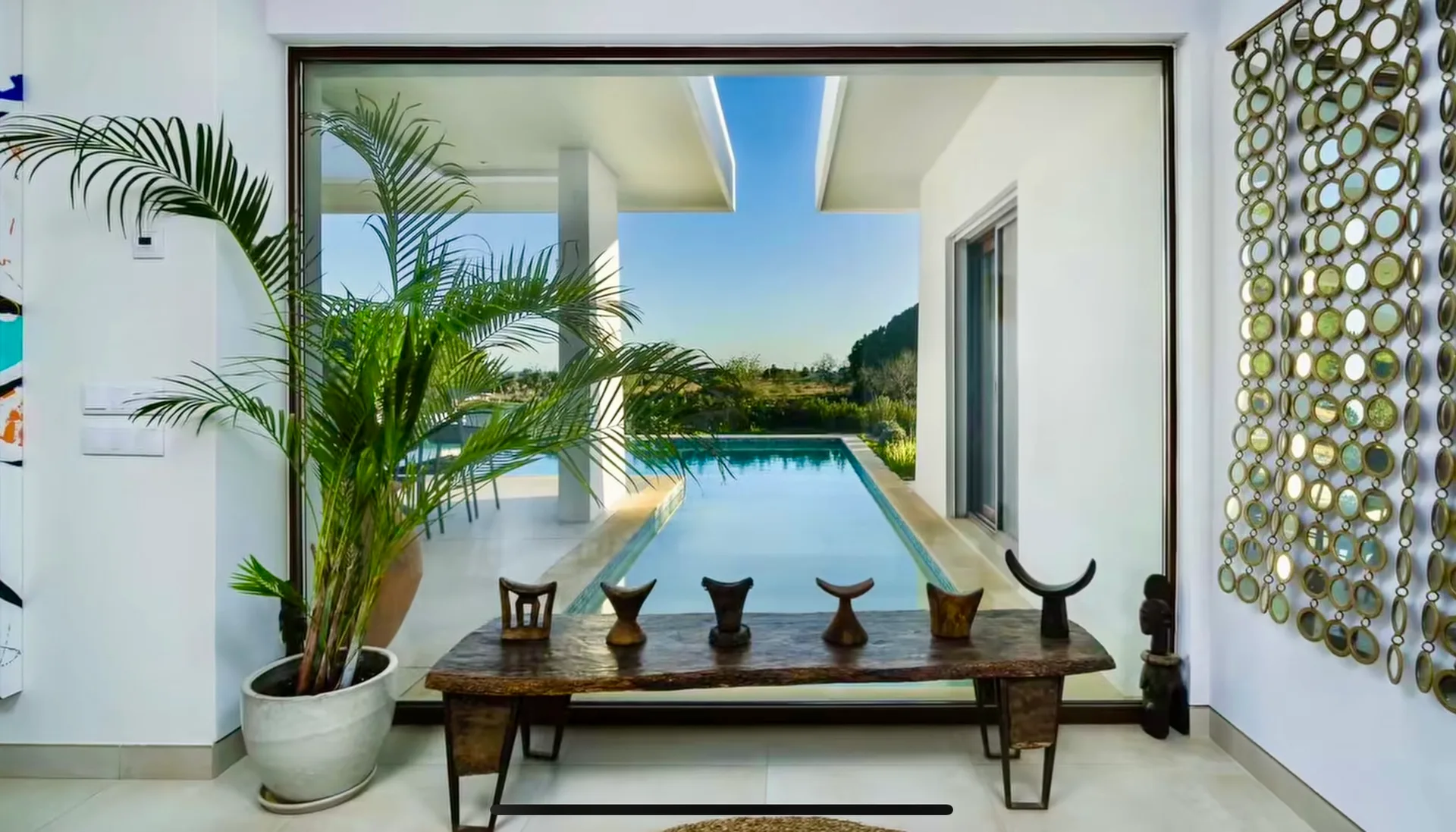 Sheltered courtyard with palms and a bench at Villa Porches