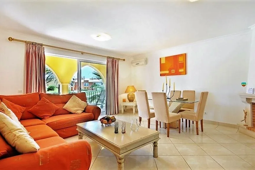Renovated living and dining room with red sofas at Jardim da Meia Praia, Lagos