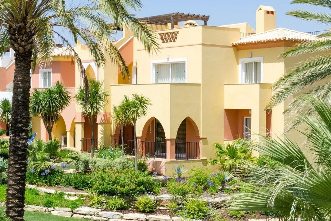 Arched resort facades and palm-lined gardens at Jardim da Meia Praia, Lagos