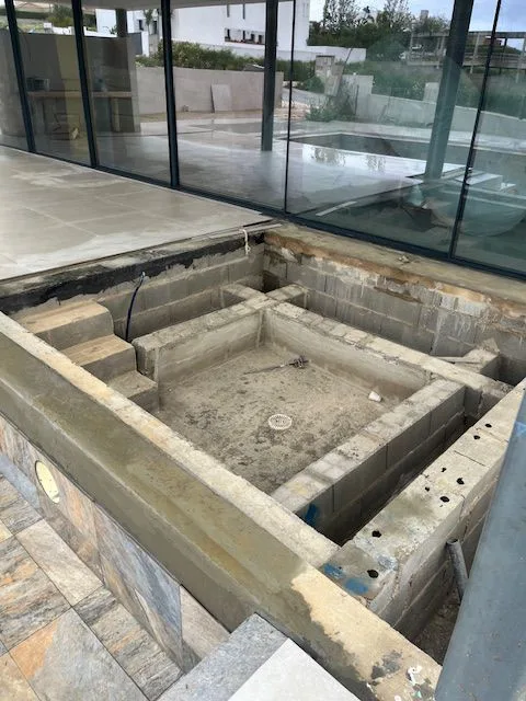 Unfinished pool area beside the villa's sliding glass doors at Porto de Mós, Lagos