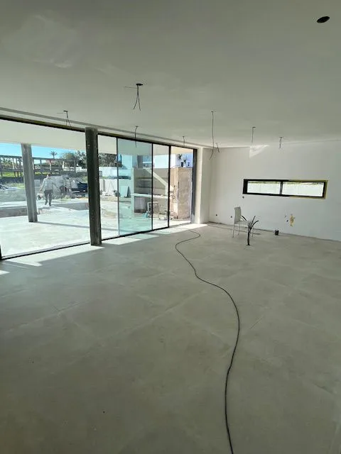 Open-plan interior with unfinished fittings and glazed doors at Porto de Mós, Lagos