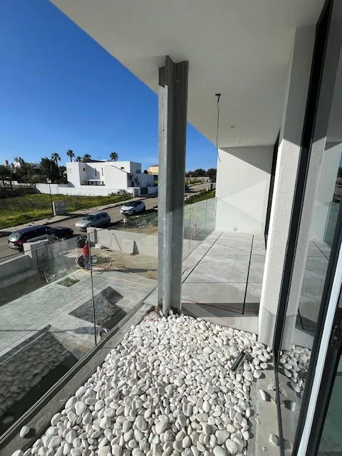 Upper balcony with glass balustrade and stone detailing at Porto de Mós, Lagos