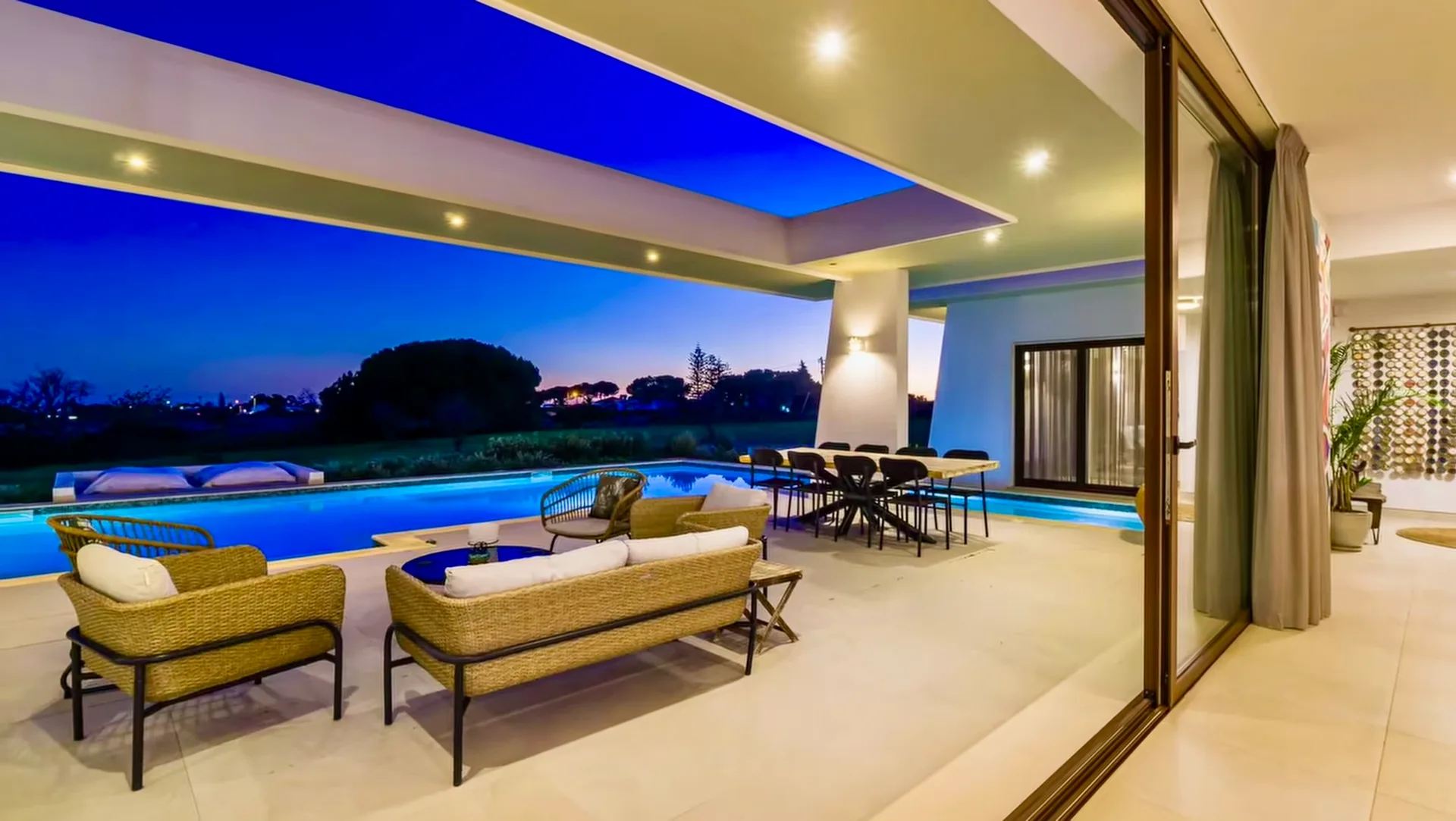 Poolside loungers and illuminated terrace at Villa Porches at dusk